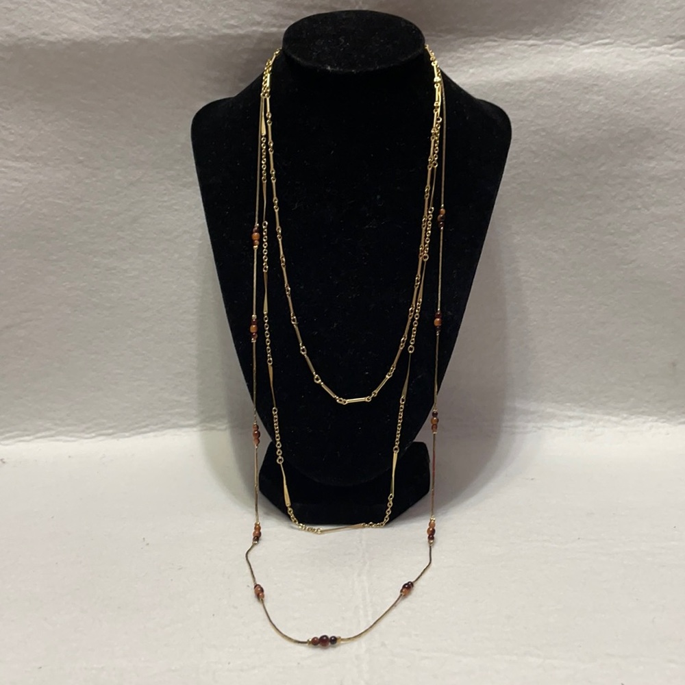 Triple strand gold tone necklace with 10”, 12.5”, and 15” drops